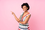 African american woman over isolated pink background pointing finger to the side