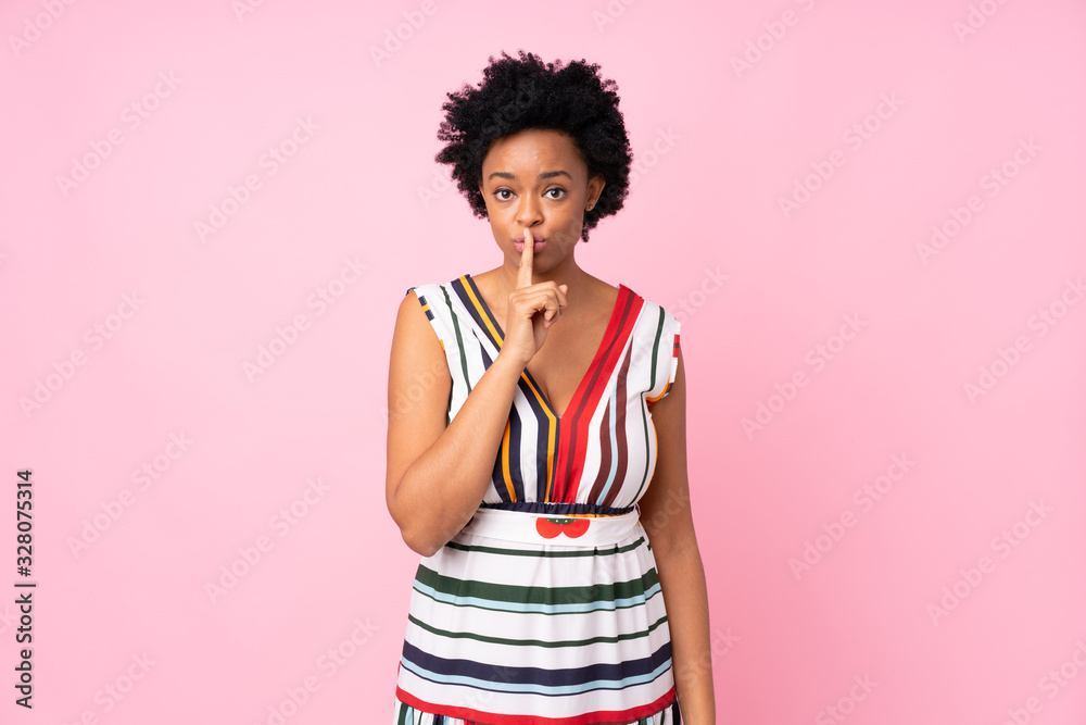 African american woman over isolated pink background showing a sign of silence gesture putting finger in mouth African american woman over isolated pink background showing a sign of silence gesture putting finger in mouth