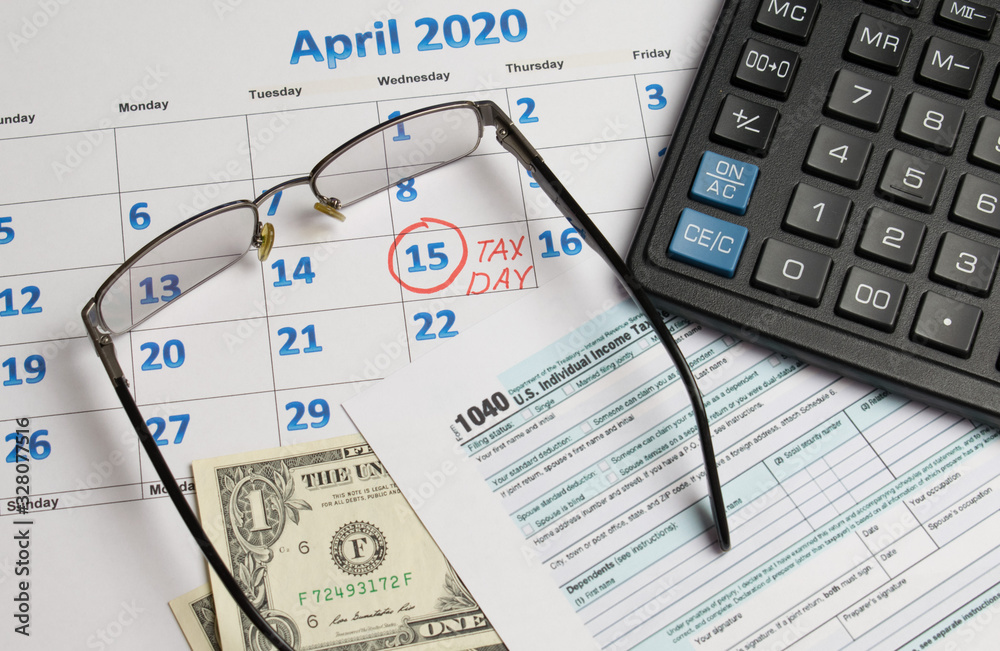 April 15 tax day calendar calculator glasses and declaration on the table April 15 tax day calendar calculator glasses and declaration on the table