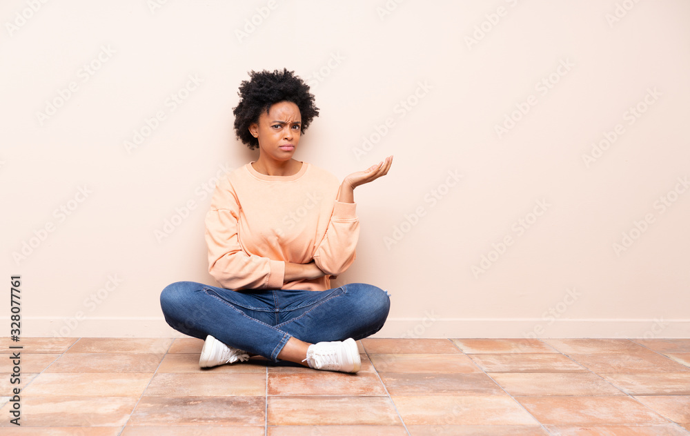 African american woman sitting on the floor unhappy for not understand something African american woman sitting on the floor unhappy for not understand something