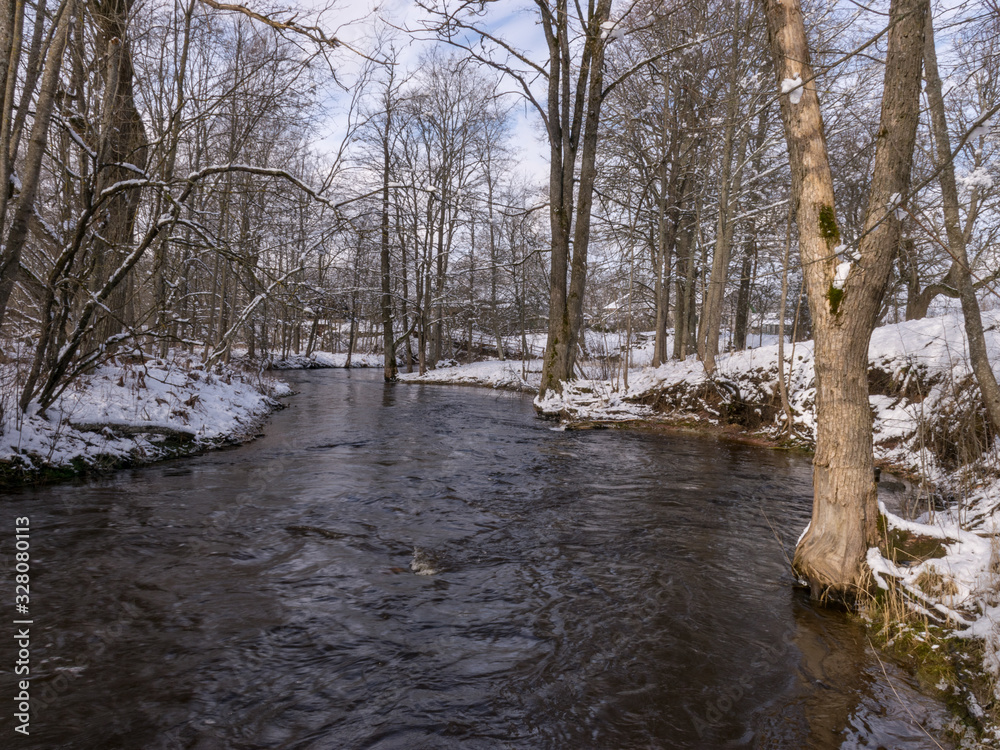 winter landscape with wild fast flowing river, snow covered land winter landscape with wild fast flowing river, snow covered land