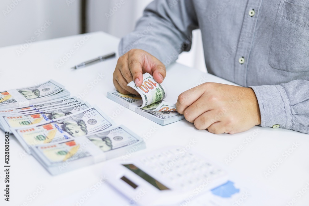Businessman analyzing investment charts and pressing calculator buttons over documents. Accounting Concept. Businessman analyzing investment charts and pressing calculator buttons over documents. Accounting Concept.