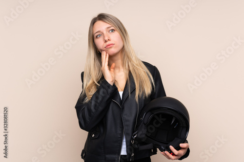 Young blonde woman with a motorcycle helmet over isolated background thinking an idea © luismolinero