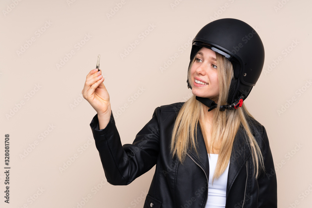 Young blonde woman with a motorcycle helmet over isolated background