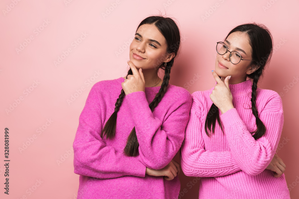 Image of two young teenage girls touching chins and looking aside Image of two young teenage girls touching chins and looking aside