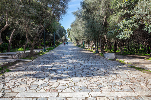 Fototapeta Naklejka Na Ścianę i Meble -  Athens, Greece. People walk on a cobblestone pathway at Filopappou hill