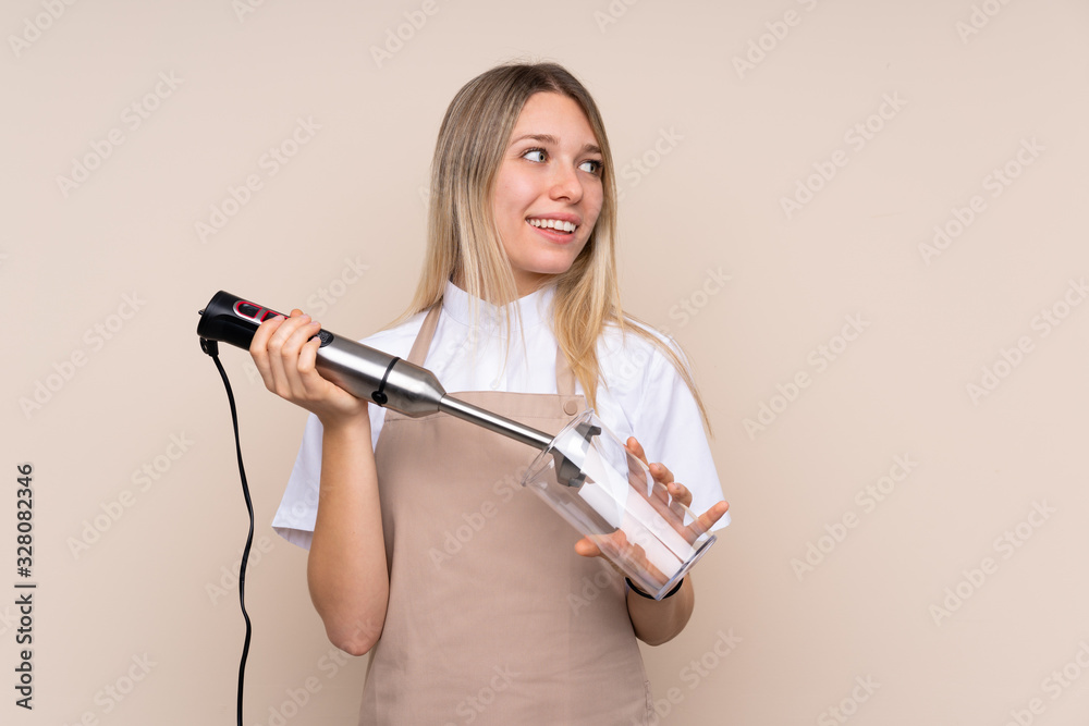 Young blonde woman using hand blender Young blonde woman using hand blender