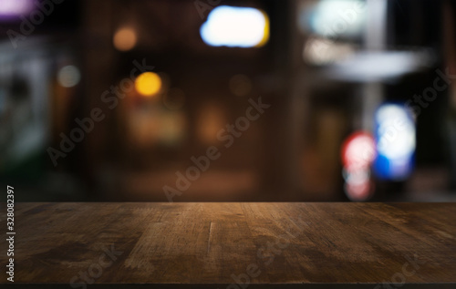 Empty dark wooden table in front of abstract blurred bokeh background of restaurant . can be used for display or montage your products.Mock up for space.