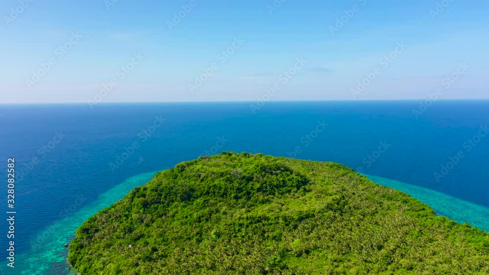 Himokilan Island, Leyte Island, Philippines. Tropical island covered in the jungle, top view. Evergreen forest on the island. Himokilan Island, Leyte Island, Philippines. Tropical island covered in the jungle, top view. Evergreen forest on the island.