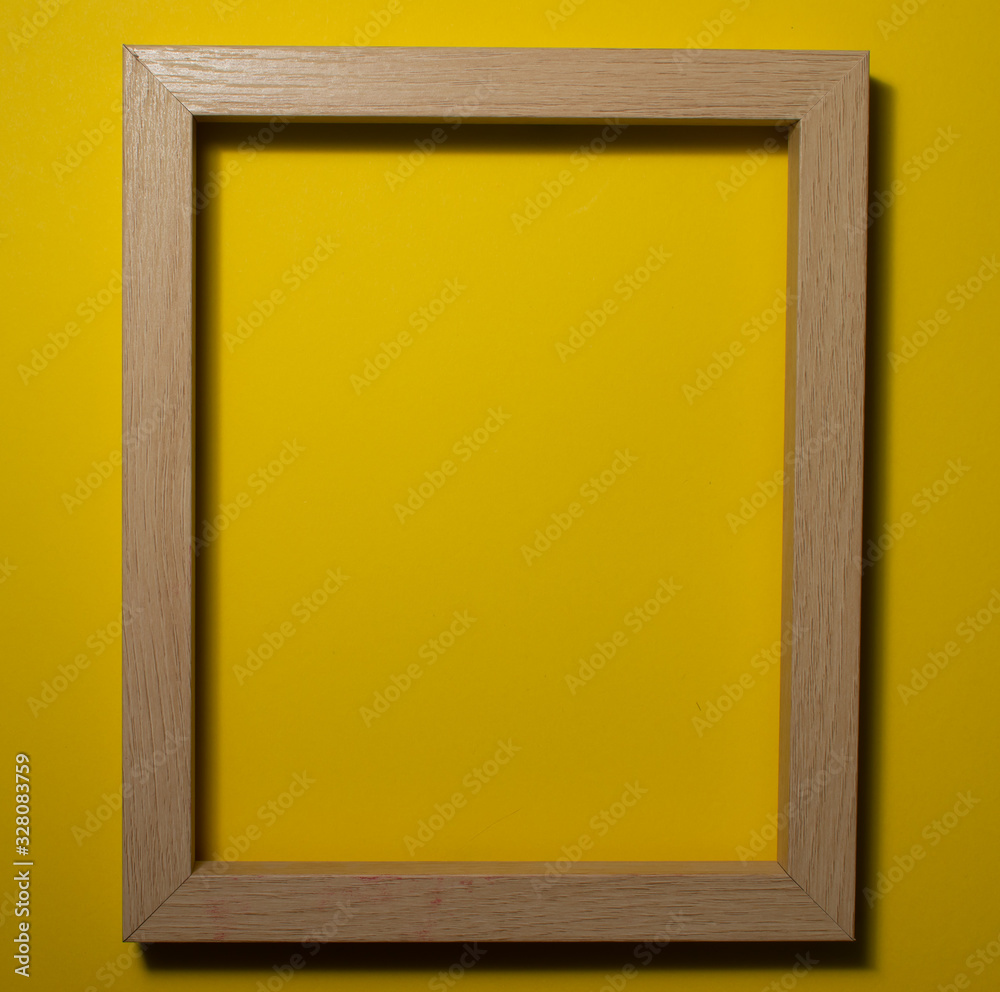 Fototapeta premium Wooden frame on a colored background. Space for copy-paste. Top view of a rectangular frame