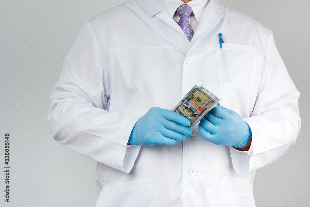 physician in a white coat, wearing blue sterile gloves, doctor holds a pack of paper money, anti-corruption concept physician in a white coat, wearing blue sterile gloves, doctor holds a pack of paper money, anti-corruption concept