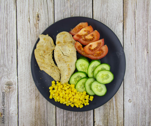 Chicken fillet with cucumbers, tomatoes and canned corn