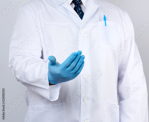 doctor in a white coat with buttons and blue latex gloves holds out his hand forward, concept of invitation