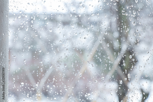 Drops on the window. On the street it is snowing heavily. March 4. Finland Espoo