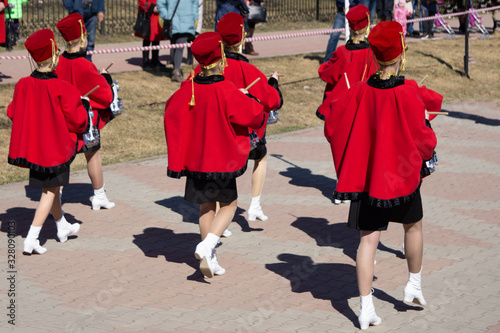 Band of musician playing and parading with red and white suit .