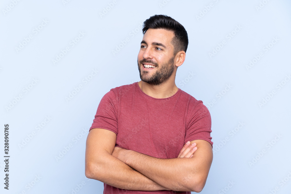 Young handsome man with beard over isolated blue background happy and smiling Young handsome man with beard over isolated blue background happy and smiling