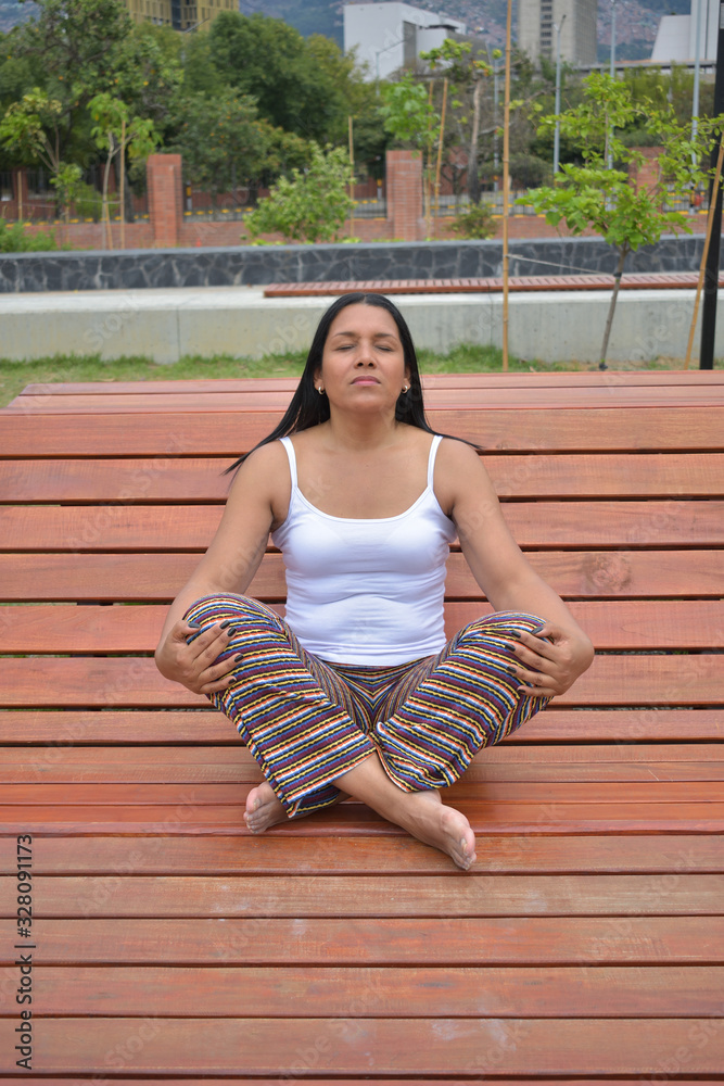 Naklejka premium Mujer morena latina haciendo ejercicios de yoga