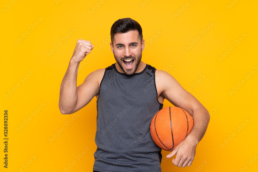 Handsome young basketball player man over isolated white wall celebrating a victory