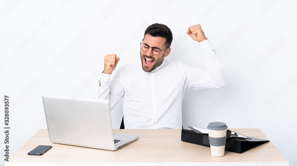 Young businessman in a workplace celebrating a victory Young businessman in a workplace celebrating a victory