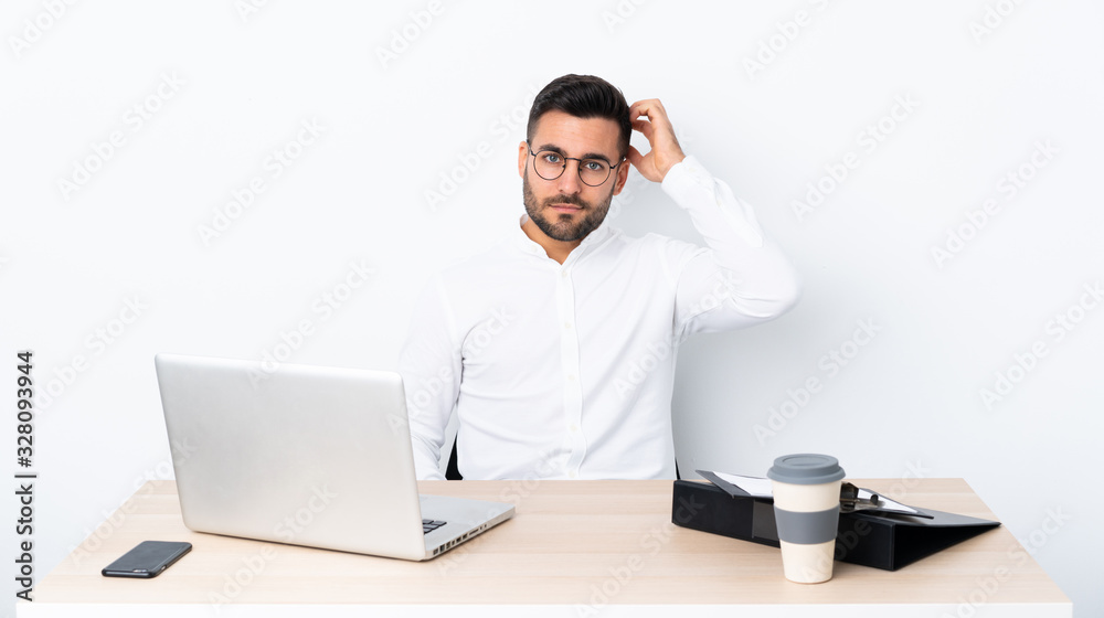 Young businessman in a workplace with an expression of frustration and not understanding Young businessman in a workplace with an expression of frustration and not understanding