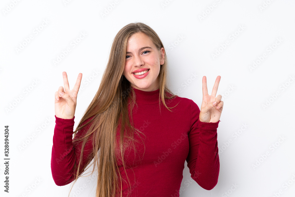 Teenager blonde girl over isolated white background showing victory sign with both hands Teenager blonde girl over isolated white background showing victory sign with both hands
