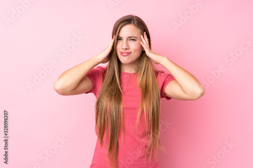 Teenager blonde girl over isolated pink background unhappy and frustrated with something. Negative facial expression © luismolinero