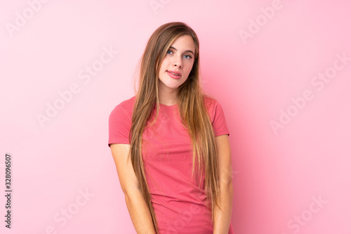 Teenager blonde girl over isolated pink background having doubts and with confuse face expression