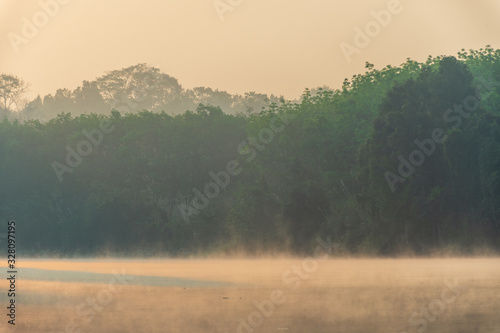 Scenic View Of Lake Against Sky During Sunrise. Steam floating above the water surface