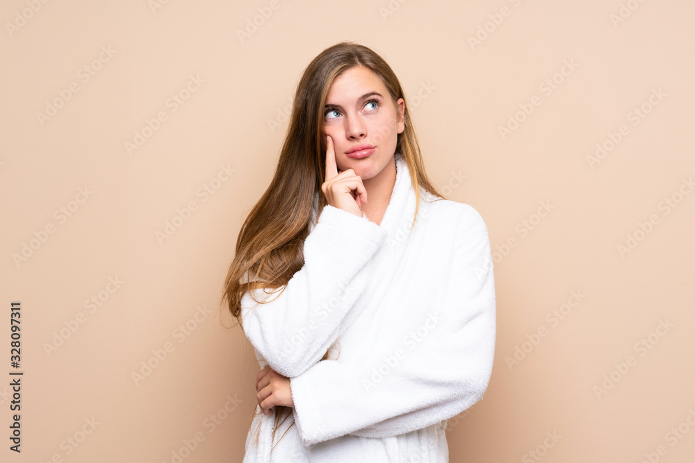 Teenager girl in a bathrobe over isolated background thinking an idea Teenager girl in a bathrobe over isolated background thinking an idea