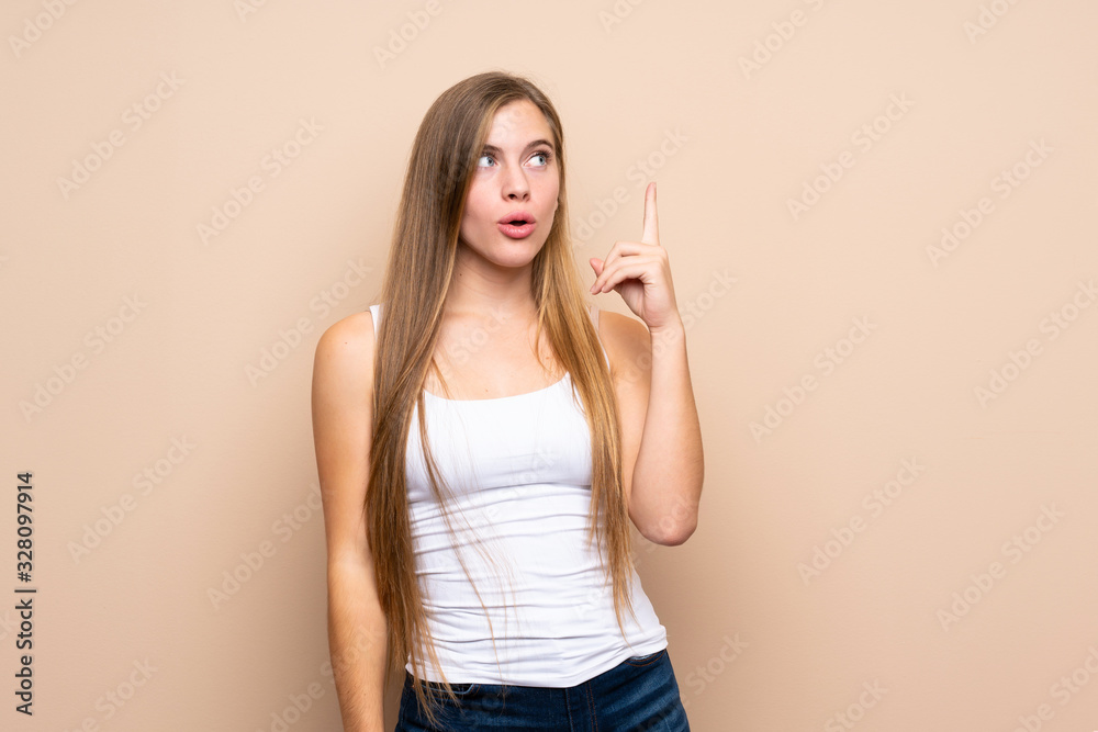 Teenager blonde girl over isolated background thinking an idea pointing the finger up Teenager blonde girl over isolated background thinking an idea pointing the finger up