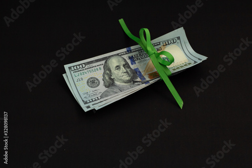 Four hundred us dollars on a black background tied with a green ribbon