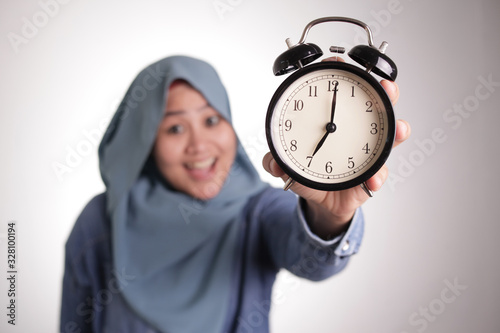 Muslim Woman Holding a Clock and Smiling, Time Management