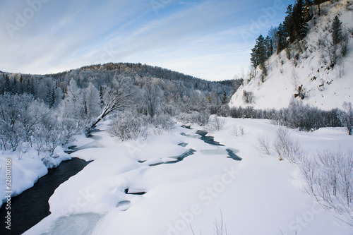 Winter river and forest covered with snow