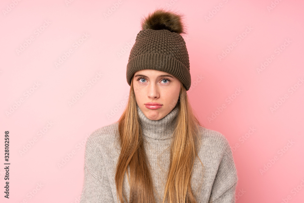 Young teenager girl with winter hat over isolated pink background sad Young teenager girl with winter hat over isolated pink background sad