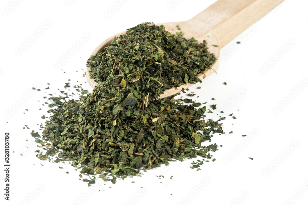 dried nettle herb or in latin Utricae folium in wooden spoon isolated on white background. medicinal healing herbs. herbal medicine. alternative medicine dried nettle herb or in latin Utricae folium in wooden spoon isolated on white background. medicinal healing herbs. herbal medicine. alternative medicine