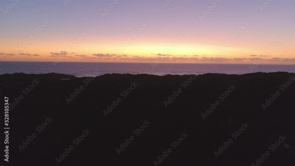 Slow rise revealing calm sea with glowing skies at dusk Slow rise revealing calm sea with glowing skies at dusk