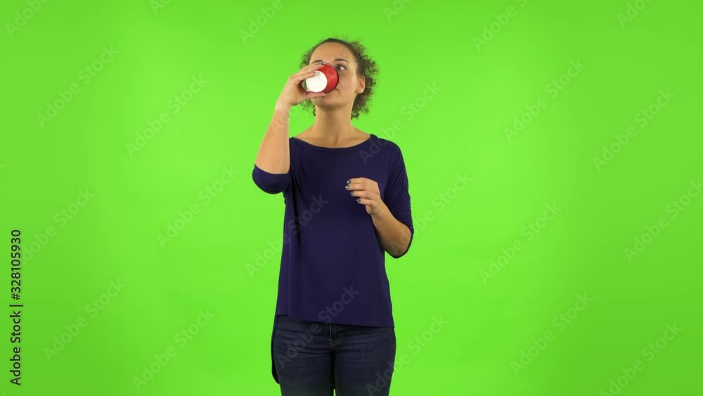 Curly woman drinking unpalatable coffee and is disgusted . Green screen Curly woman drinking unpalatable coffee and is disgusted . Green screen
