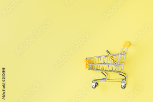 shopping trolley isolated on yellow background