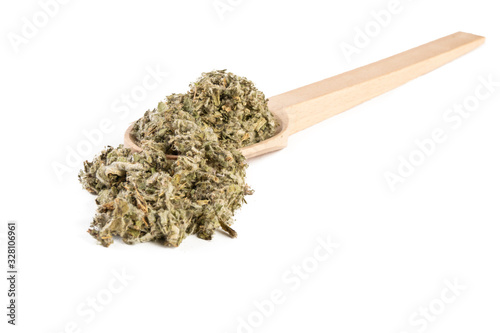 dried artichoke leaves or in latin Cynarae folium in wooden spoon isolated on white background. medicinal healing herbs. herbal medicine. alternative medicine