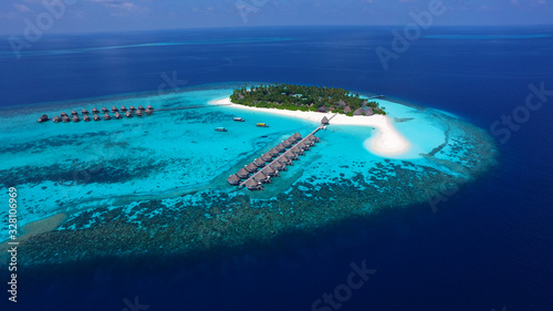 Traumhafte Südseeinsel mit türkiesfarbenem Riff auf den Malediven mit Palmen und weißem Sandstrand