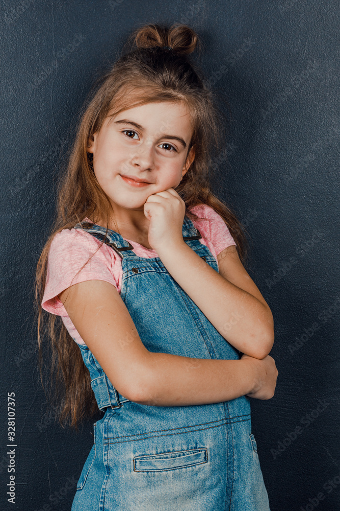 Portrait of a fun cute adorable cute cute little girl showing a thumbs up. Isolated on a black background. Portrait of a fun cute adorable cute cute little girl showing a thumbs up. Isolated on a black background.