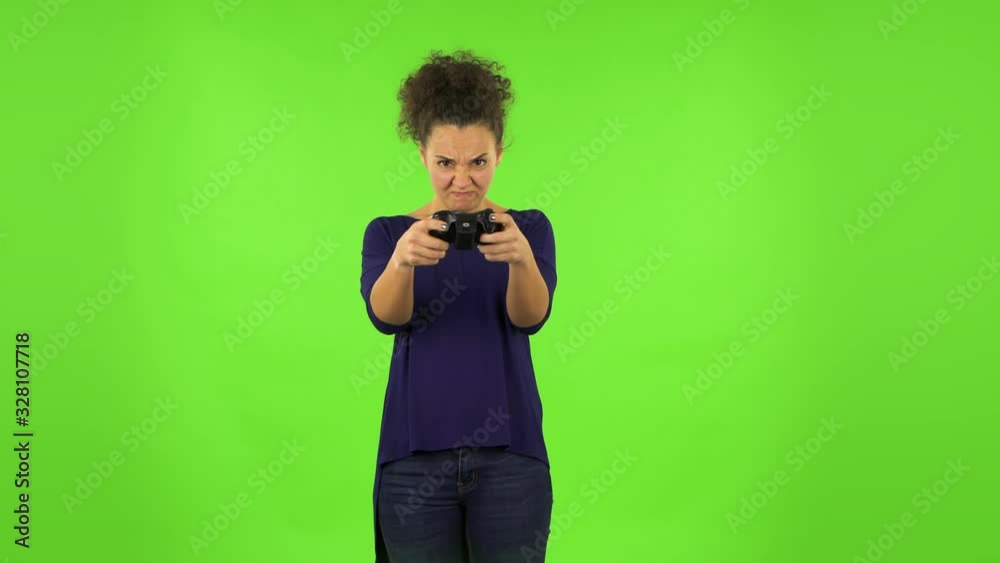 Curly woman playing a video game using a wireless controller and loses. Green screen Curly woman playing a video game using a wireless controller and loses. Green screen