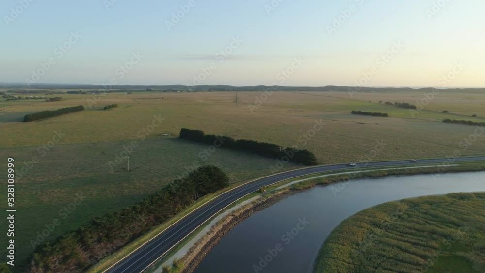 Drone flight following winding river revealing sun at sunset in Australia Drone flight following winding river revealing sun at sunset in Australia