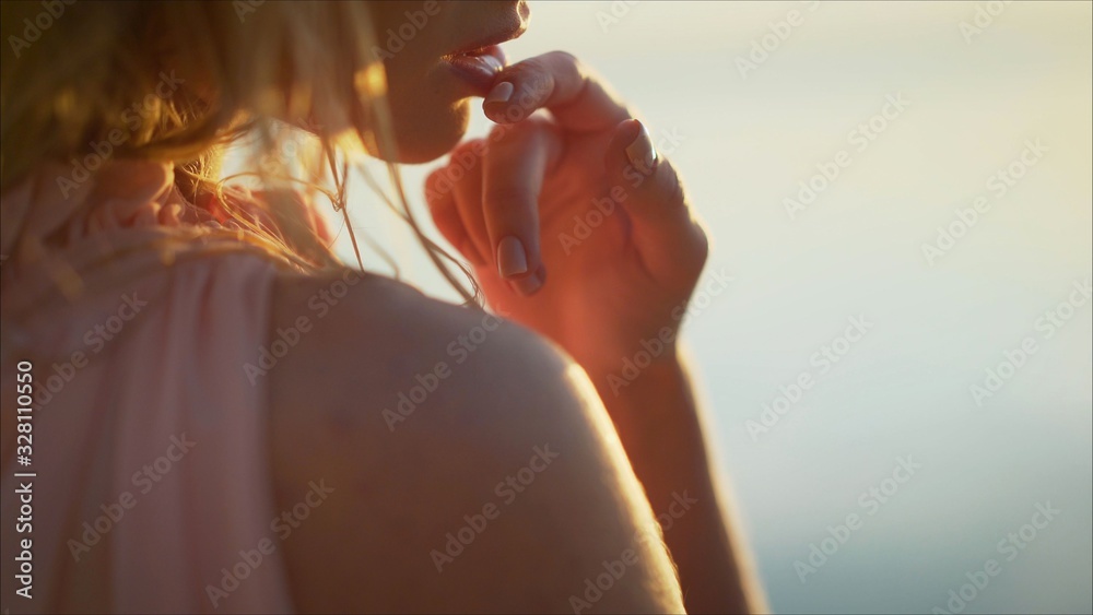 Obraz premium Young tender girl in the water against the background of dawn. sexy girl on the beach. Young woman on sunset sky and water