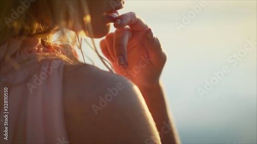 Young tender girl in the water against the background of dawn. sexy girl on the beach. Young woman on sunset sky and water