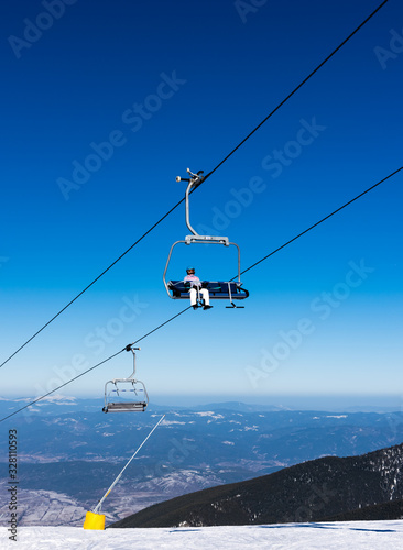 Snowy ski slopes and chair ski lifts station in mountain ski resort.