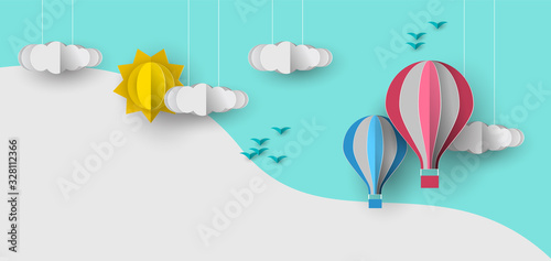 Cute papercut sky landscape background with white copy space. Hot air balloon, sun and clouds made in realistic paper craft art or origami style for baby nursery, children design.