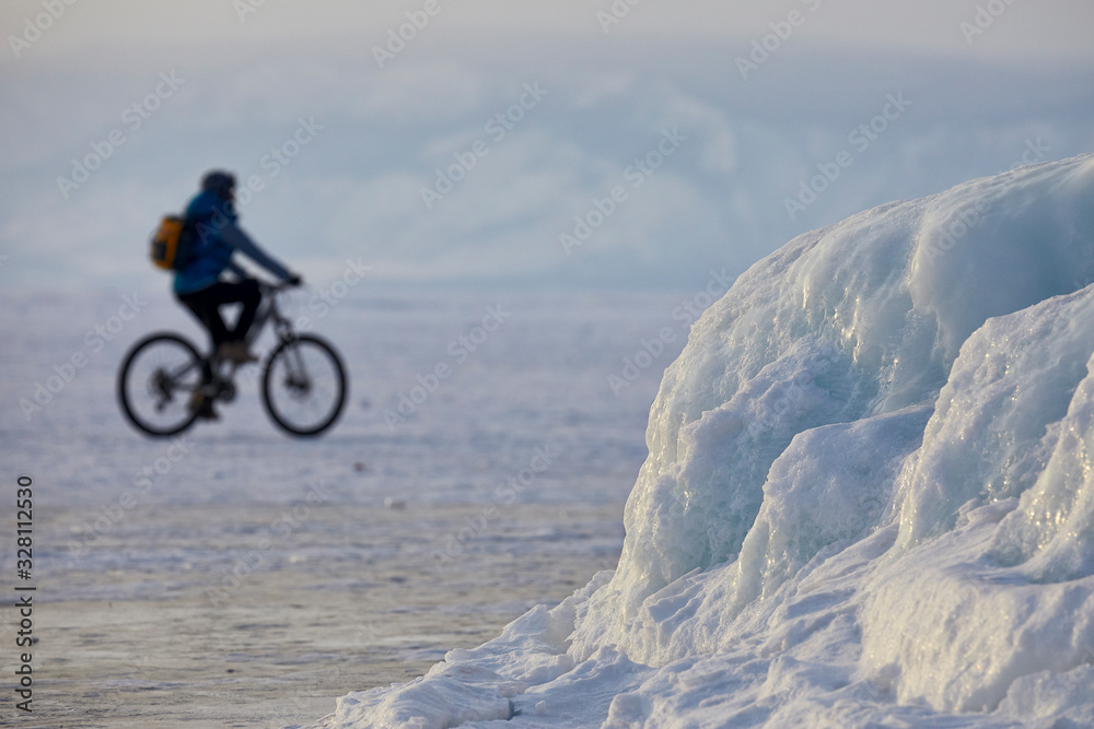 A cyclist rides on a snow-covered lake Baikal A cyclist rides on a snow-covered lake Baikal