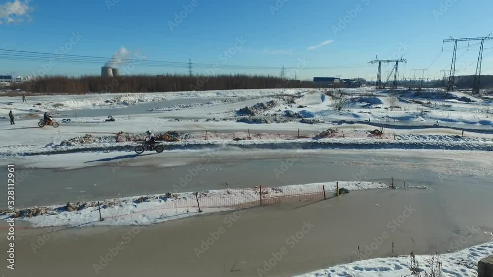 a motorcyclist performs stunts on a winter track a motorcyclist performs stunts on a winter track