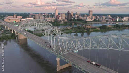 Aerial flying over traffic on the Hernando de Soto Bridge that crosses the Mississippi River at sunset. In the background is downtown Memphis, Tennessee, USA photo